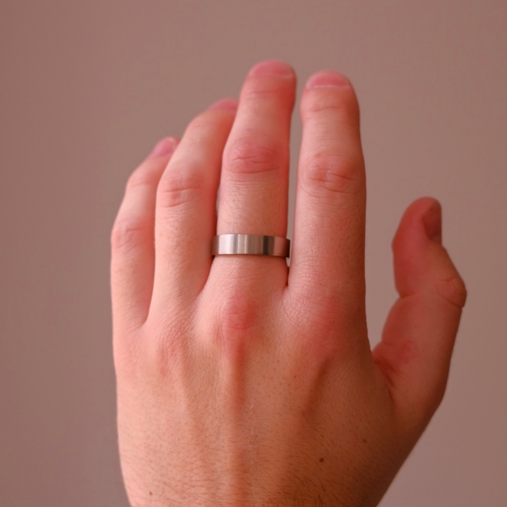 Mens Brushed Silver Band Ring Modelled on middle finger. Everyday steel silver brushed band ring for him